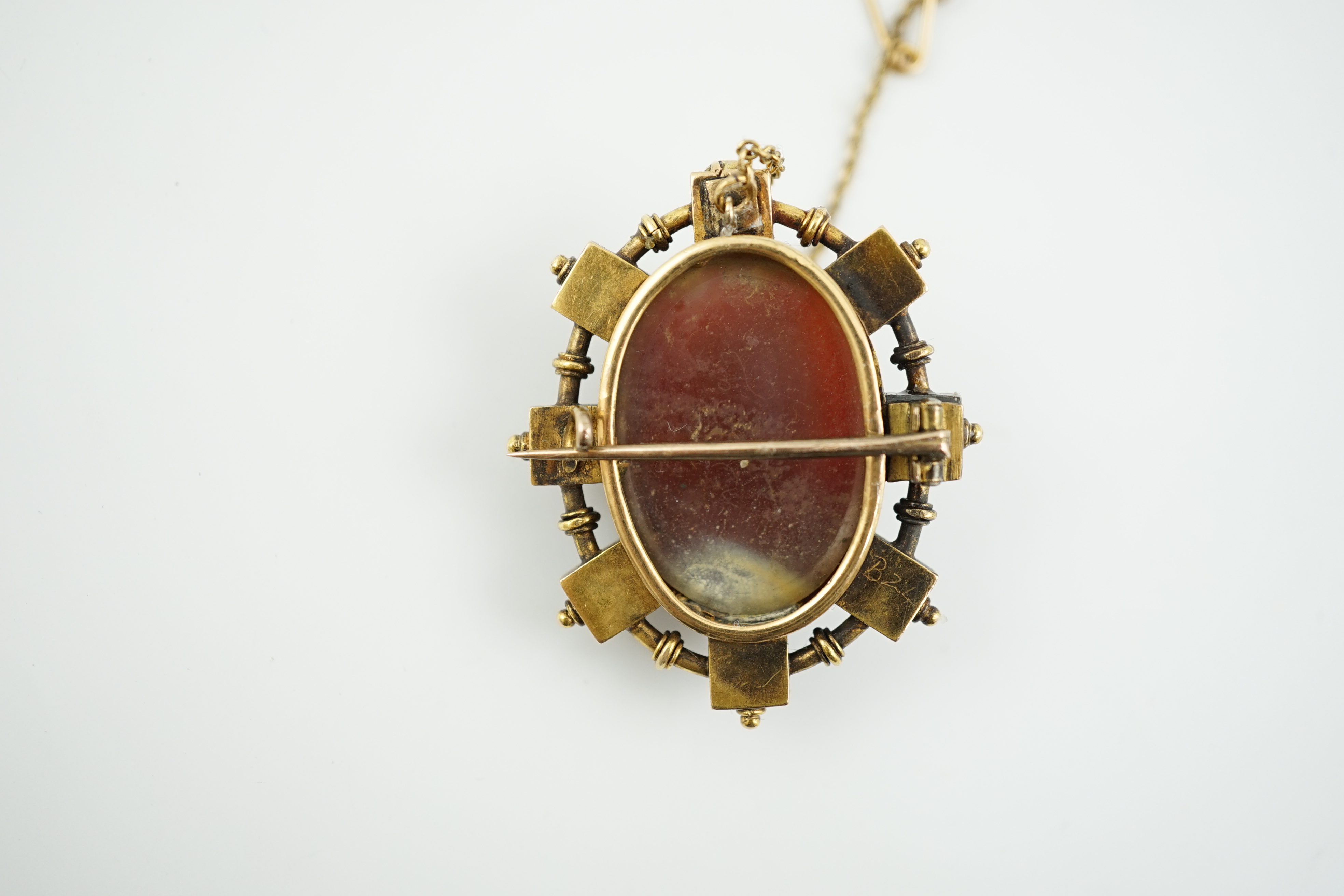 A Victorian gold and split pearl mounted oval hardstone cameo brooch, carved with the bust of a gentleman to dexter